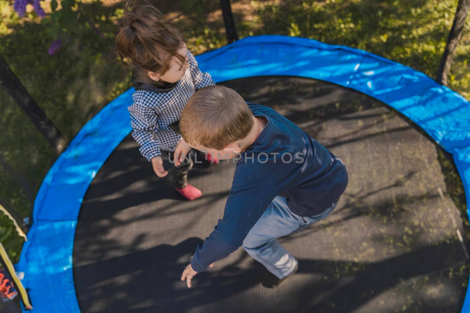 children jumping on a trampoline top view