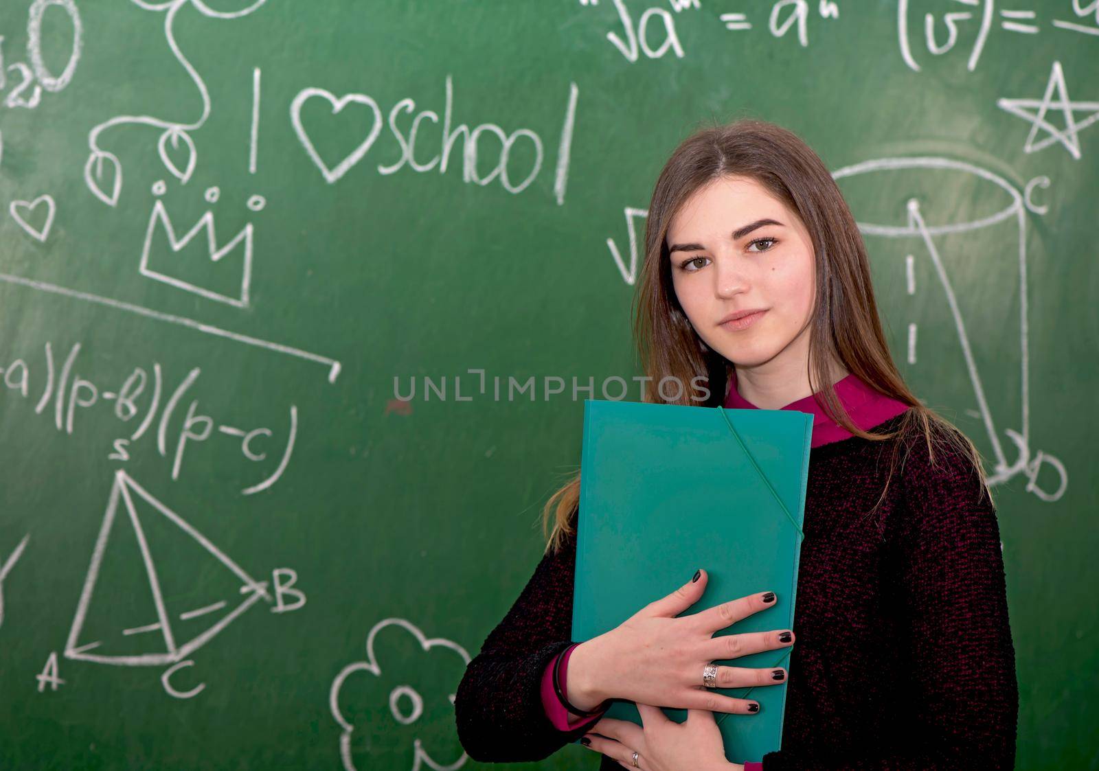 portrait of happy cute student near blackboard