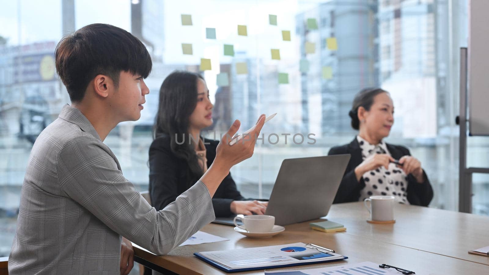 Concentrated group of diverse business partners listening intently during discussion of development strategy at meeting.