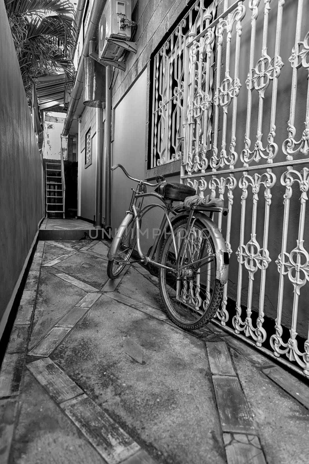 Old bicycle in black and white. Bike left at the fence on the street by EdVal