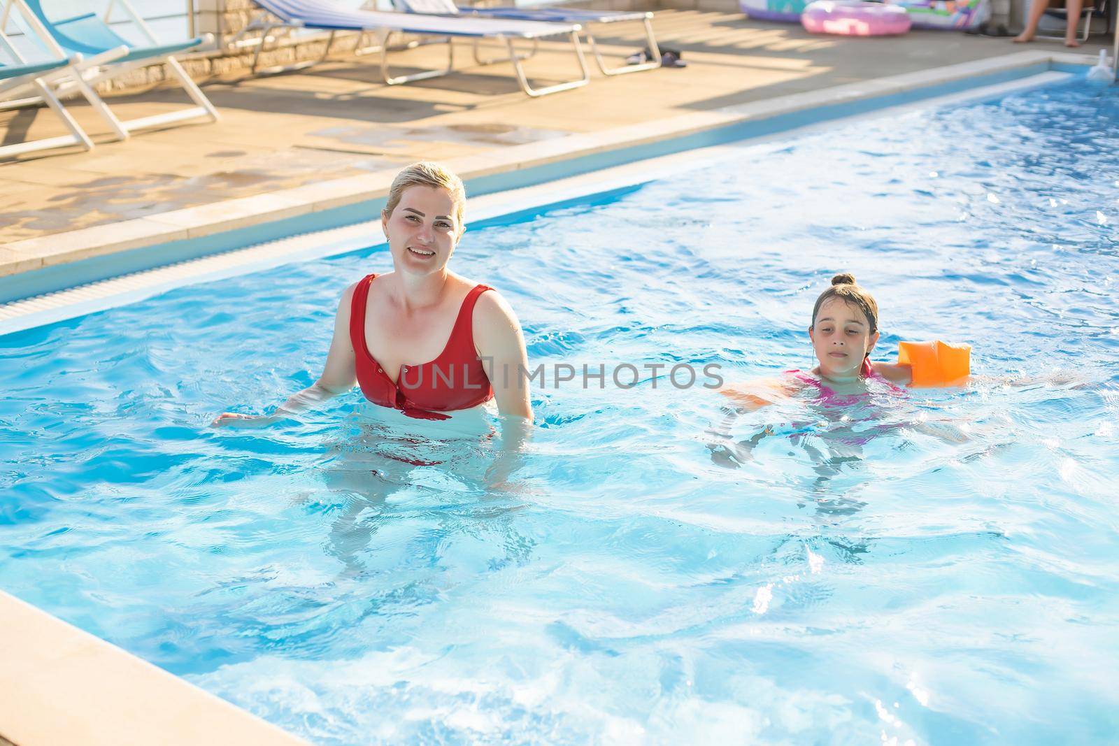 A mother and daughter playing in the pool.