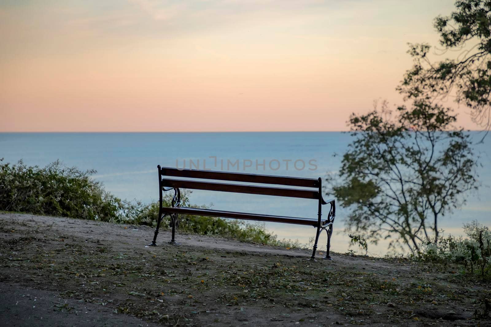Wooden bench with a view at sea and day sky. Beautiful place for relaxing and enjoying nature. Traveling stop for travelers. 