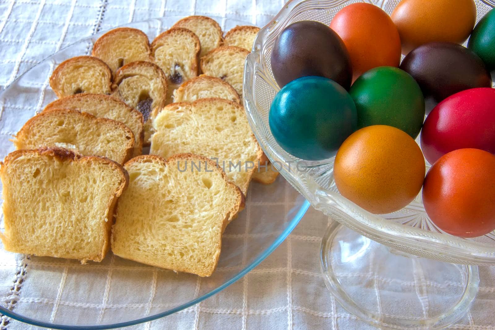 Easter traditional bread and colorful Easter eggs in a plate on the table