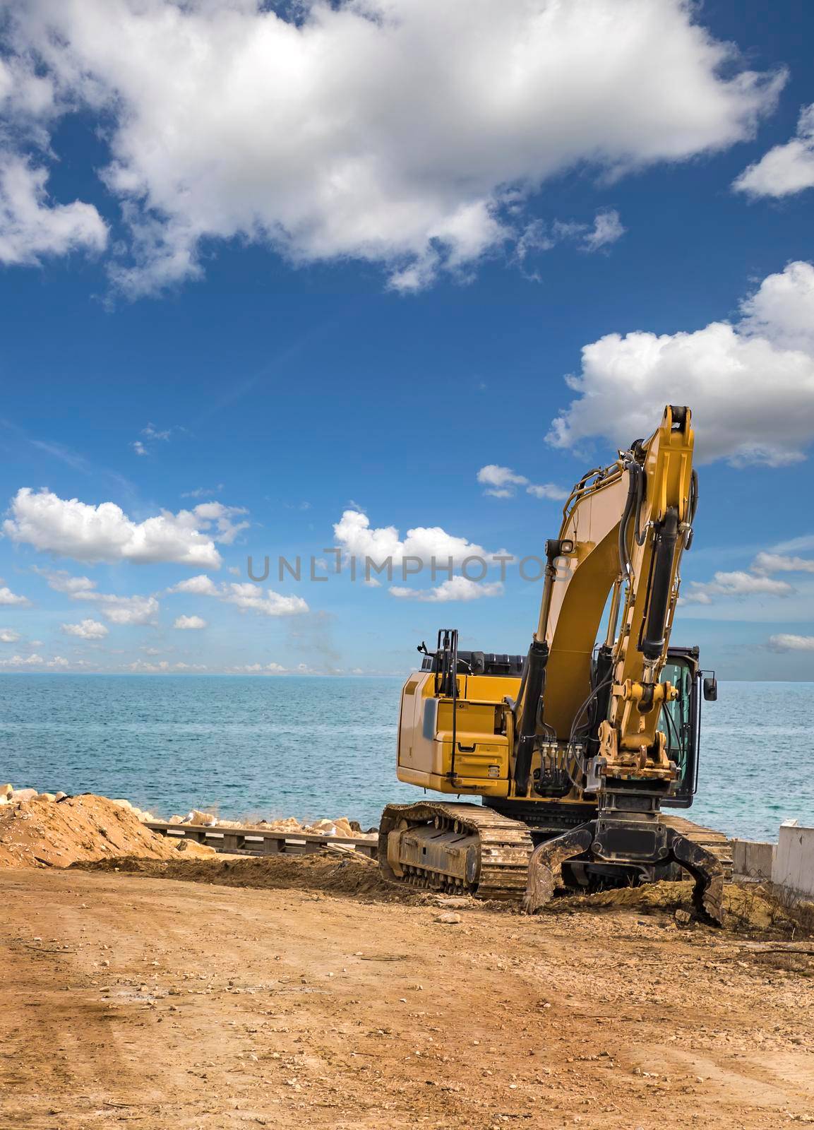 Crawler excavator after works at the construction site at sea beach
