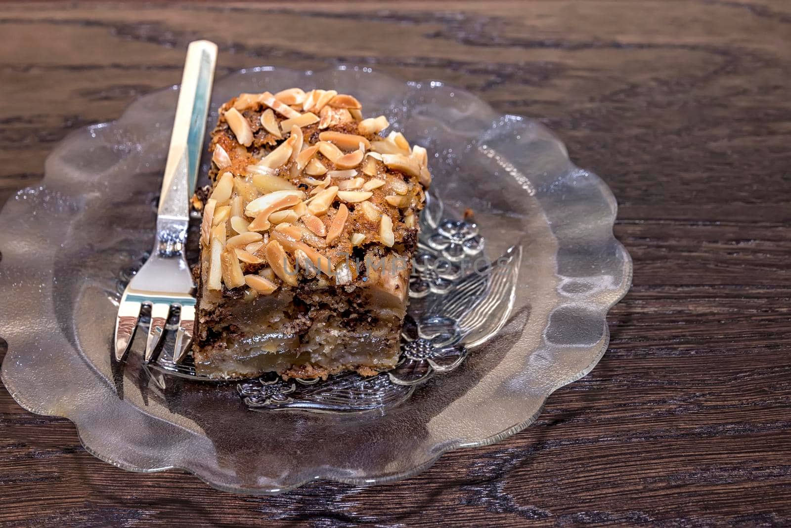 Delicate piece of chocolate cake, torte with nuts on a plate with a fork. 