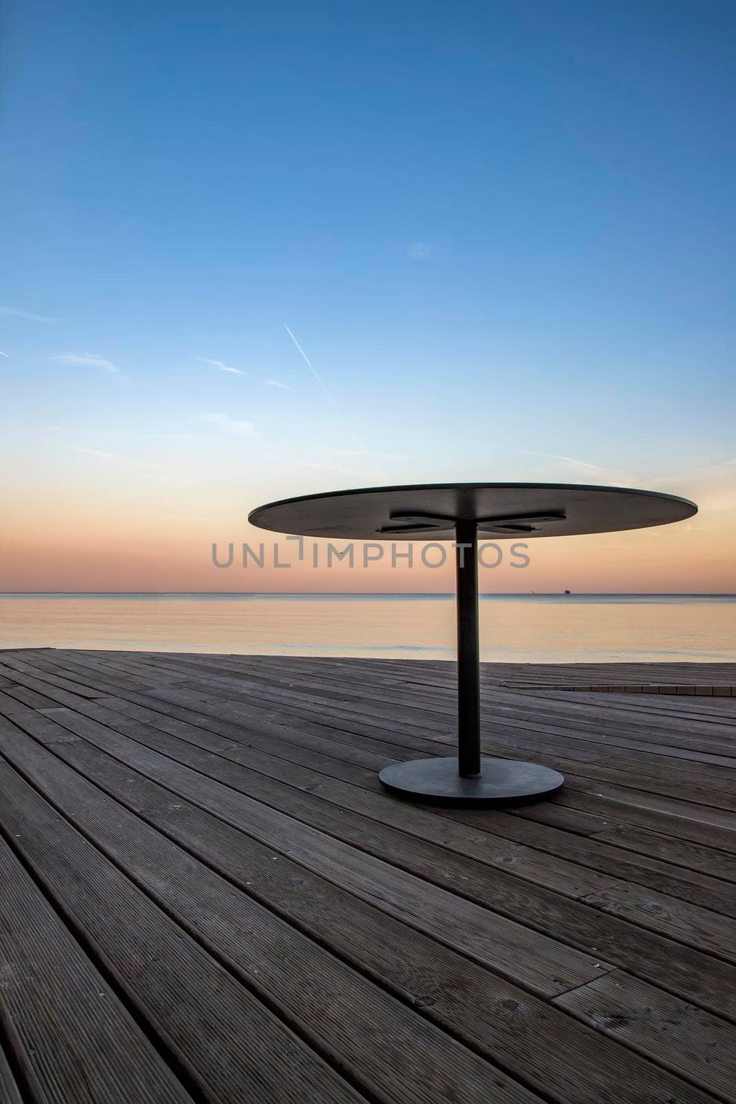 Tranquil view of an empty table at the beach. Vertical view