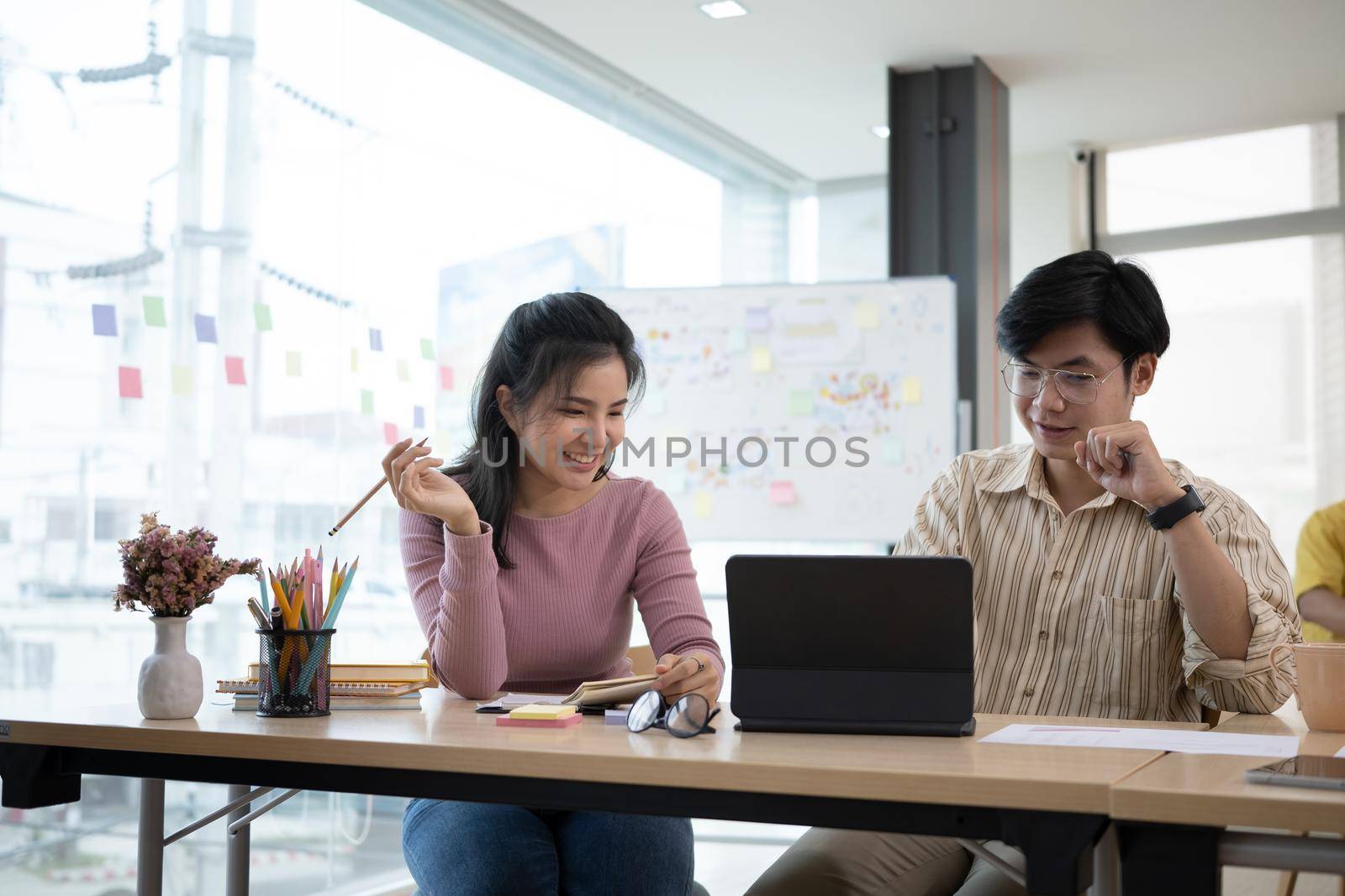 Two startup employee consulting with digital tablet in modern office.