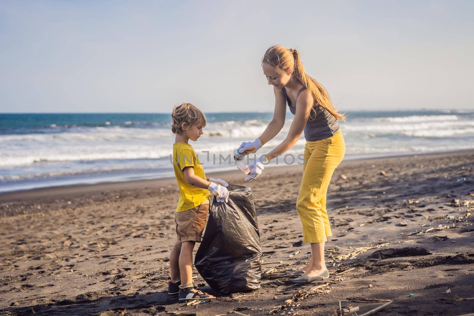 Mother and son are cleaning up the beach. Natural education of children by galitskaya
