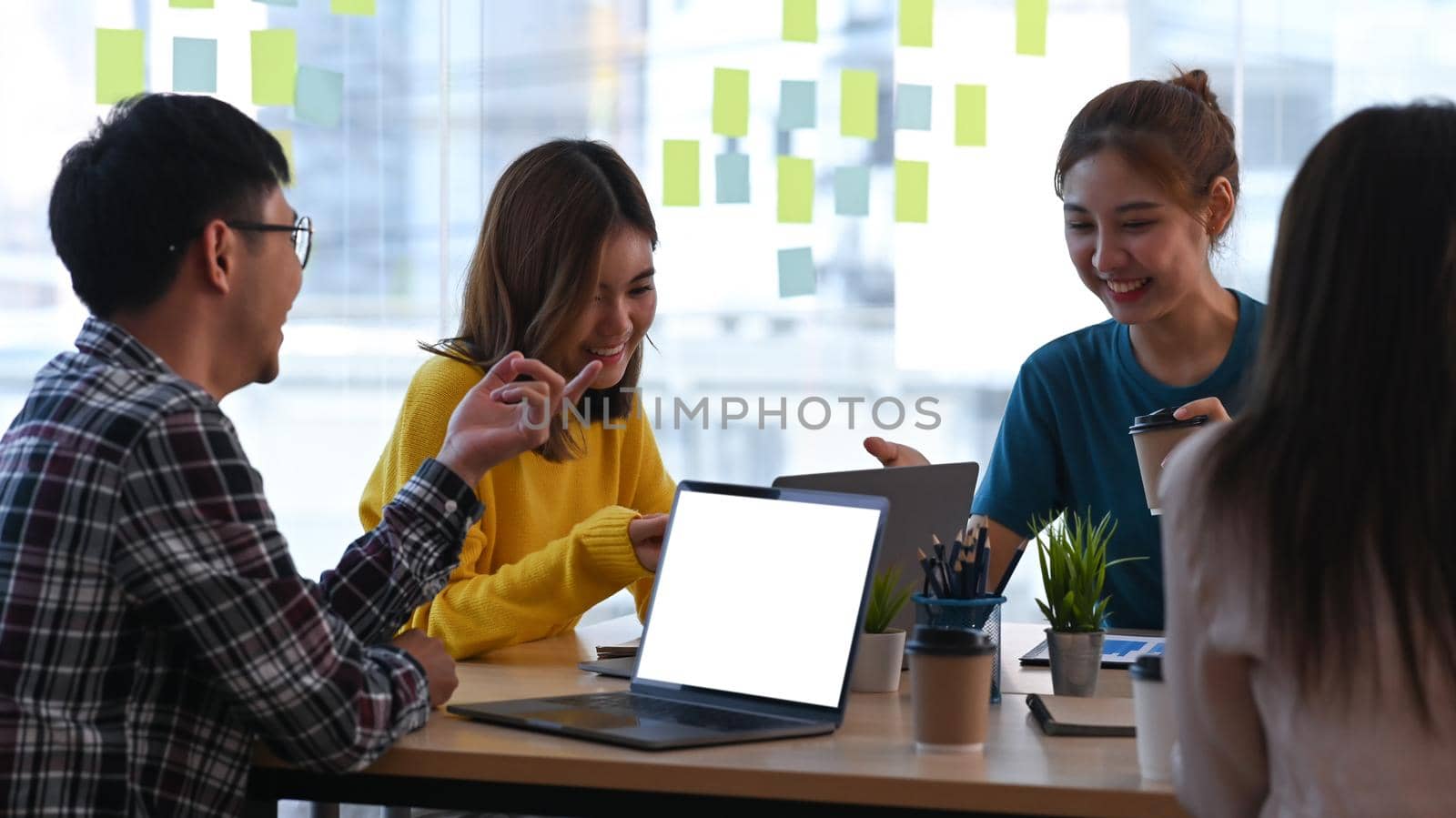 Group of young businesspeople discussing ideas of the new startup project together at modern office. by prathanchorruangsak