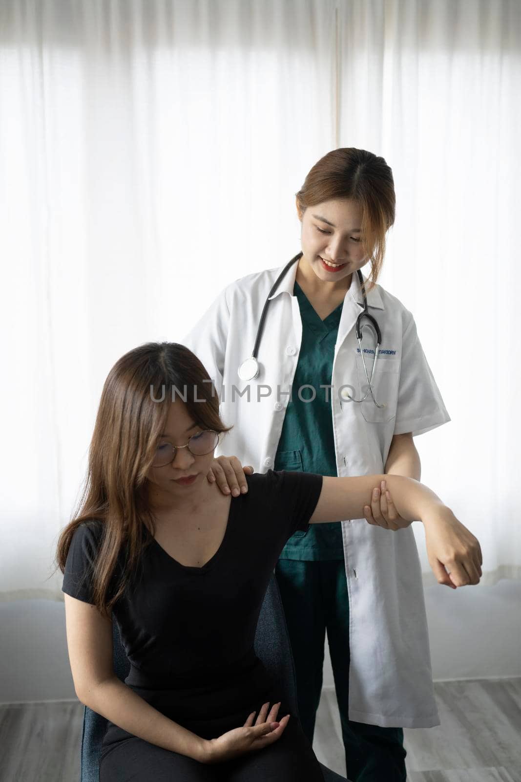 Caring female physiotherapist working with patient in clinic. Physiotherapist Insurance concept. by prathanchorruangsak