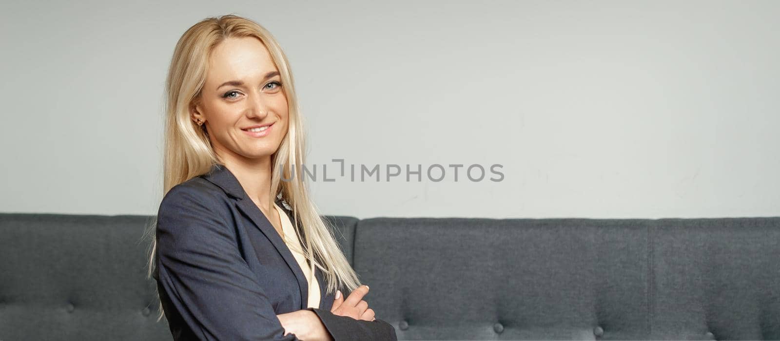 Beautiful caucasian business woman smiling at the camera with folded arms in office.