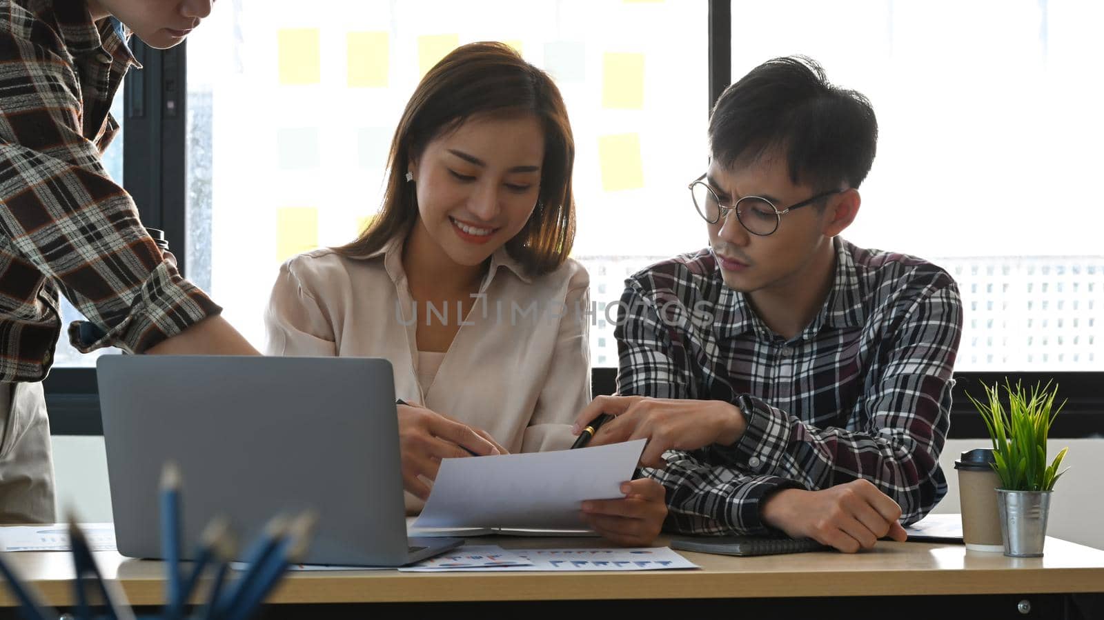 Asian male business leader explaining new project and discussing corporate business plan with his colleague. by prathanchorruangsak