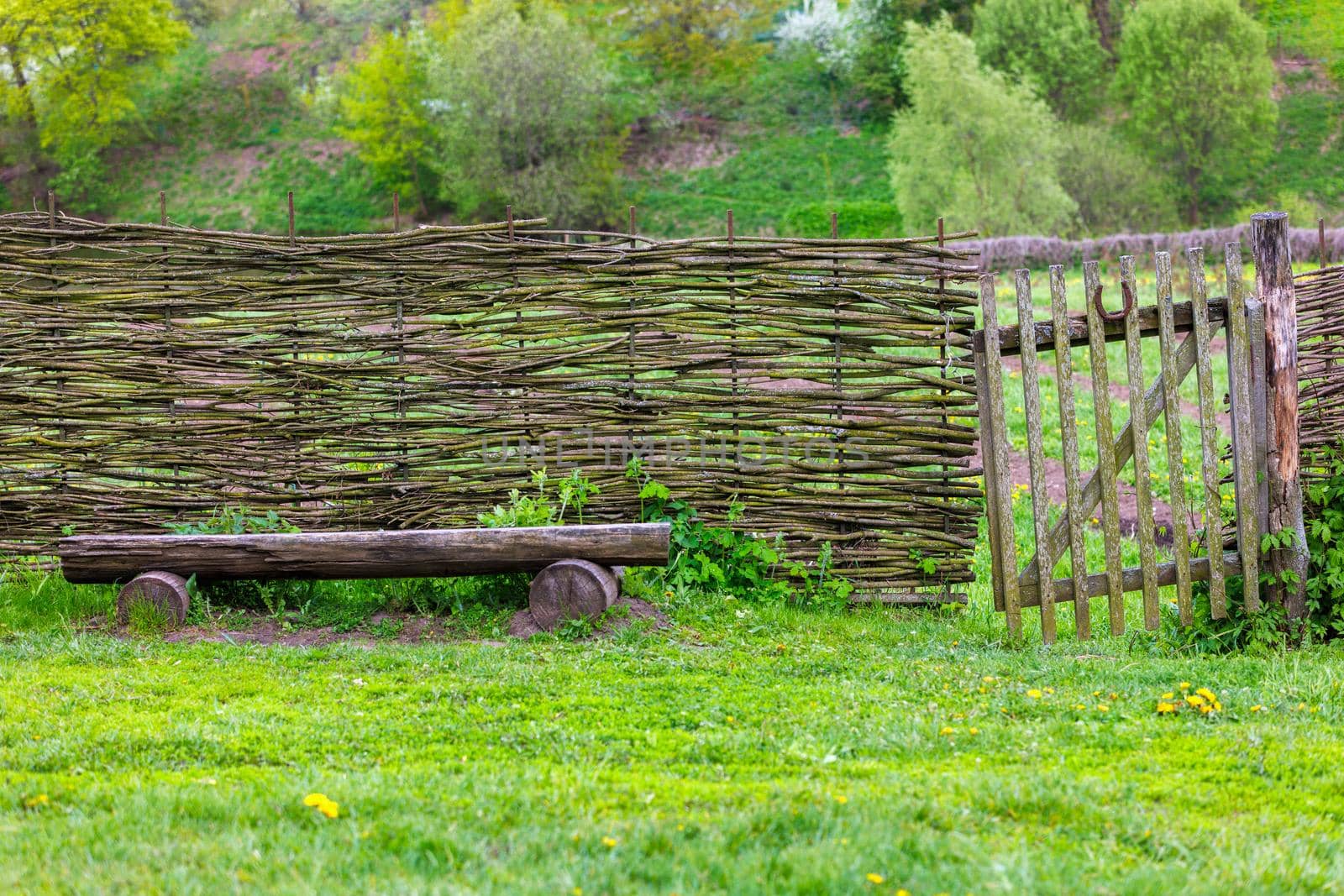 horizontal wattle fence with wicket and wooden bench near at summer day in Yasnaya Polyana, Russia