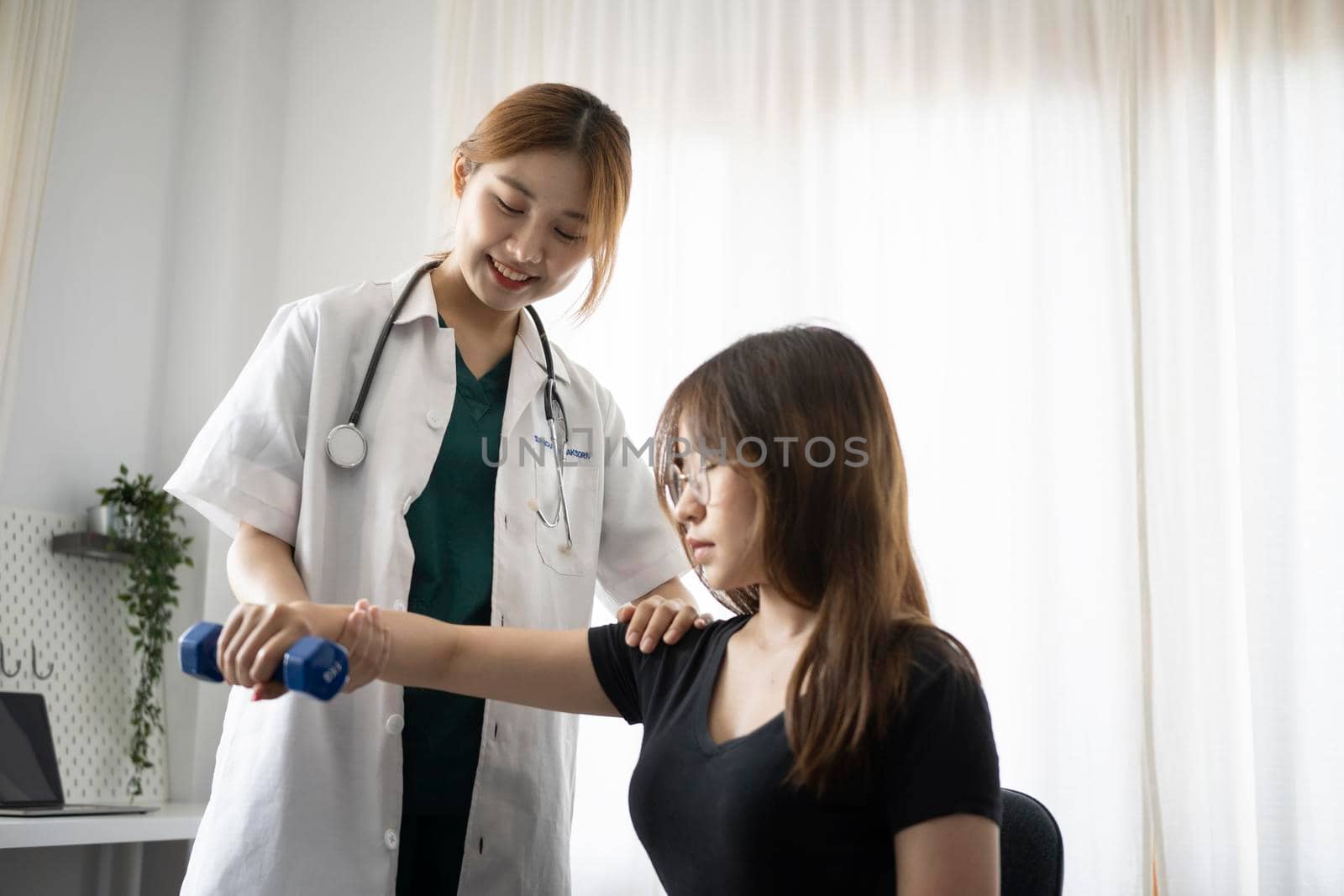 Young woman getting physical arm treatment from physiotherapist. Healthcare concept. by prathanchorruangsak