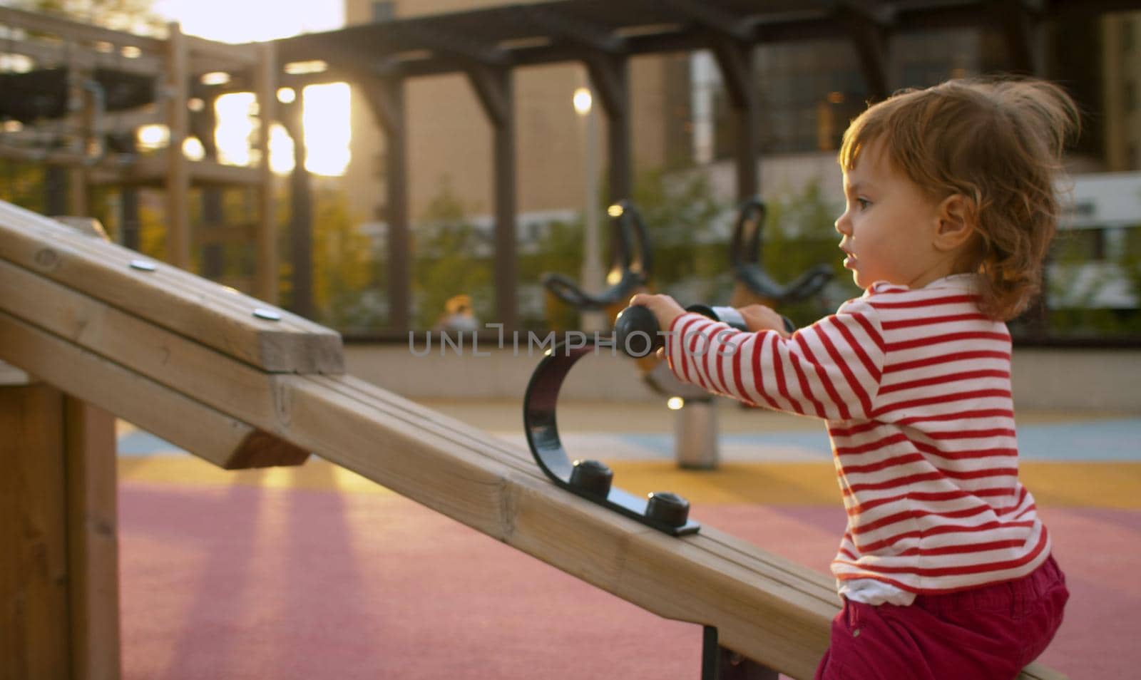 Little girl on the playground in the park. Good sunny day