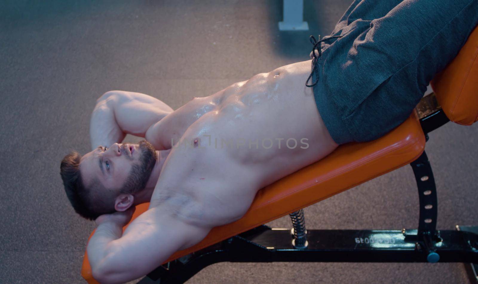 Strong bodybuilder doing abs exercises in the gym