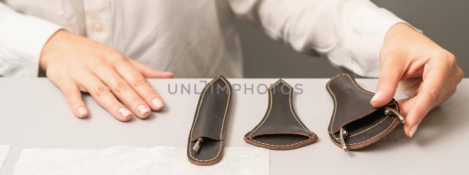 Manicurist is laying out manicure professional tools on table in beauty salon.