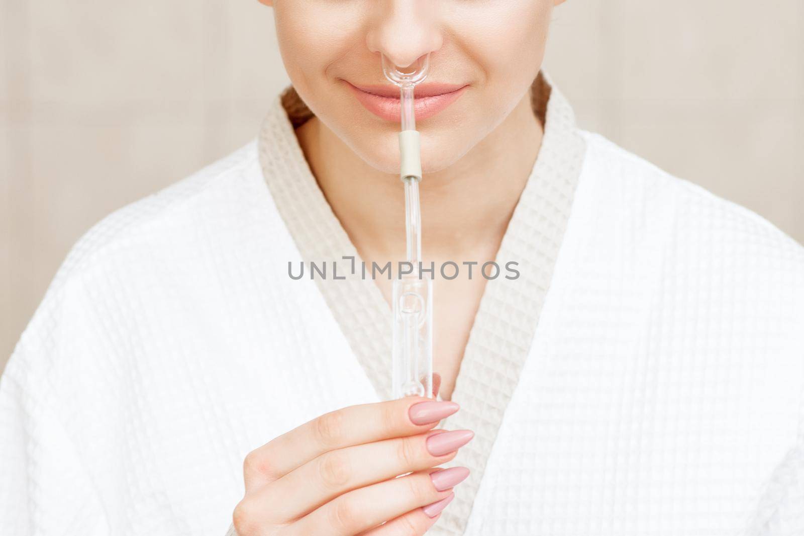 Woman receives nasal inhalation Maholda by essential oil in nose at spa.