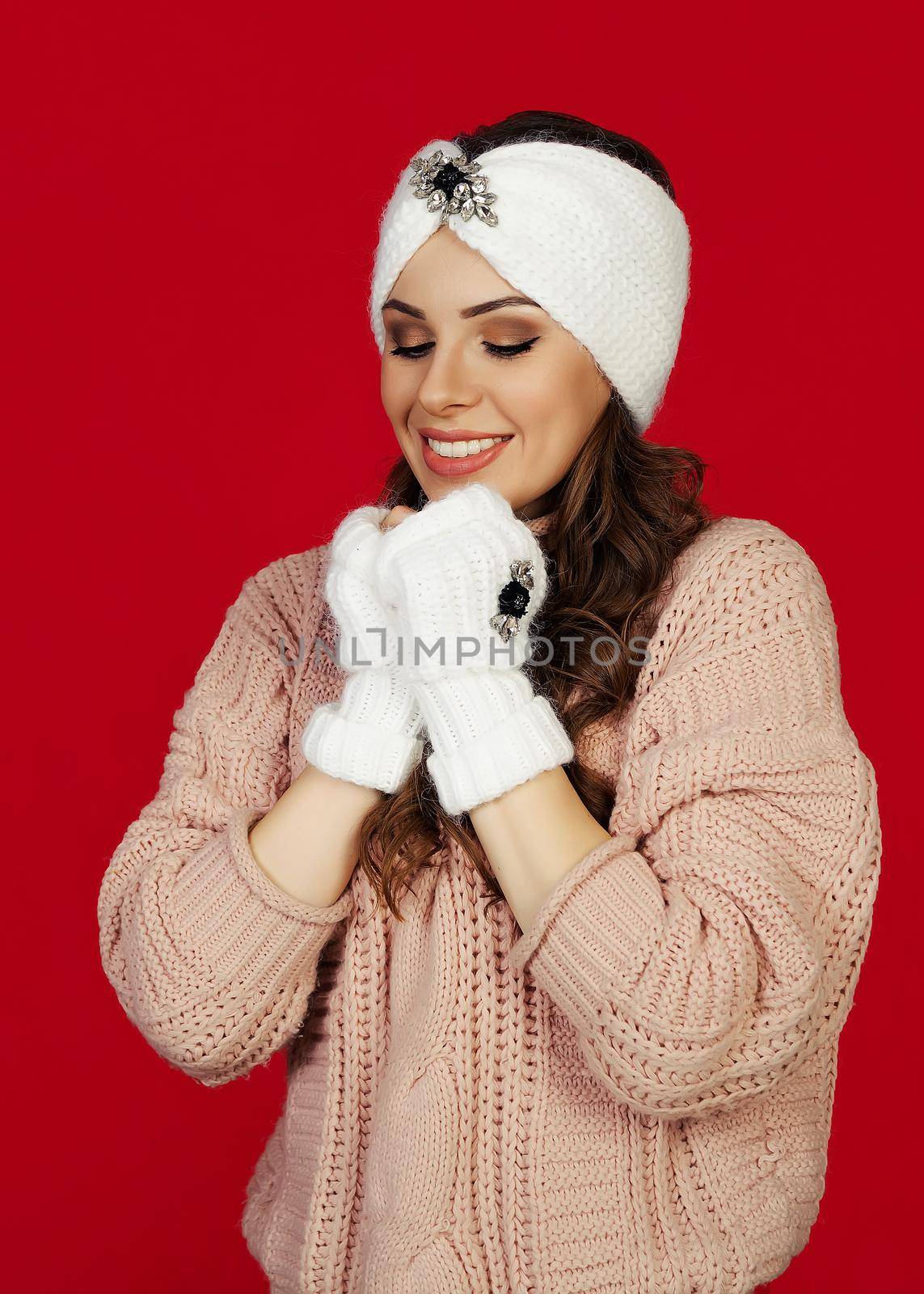Portrait of a happy girl in a good mood, she made her hands and is waiting for a surprise gift, the atmosphere of winter holidays. A young woman in the taste of a long-awaited gift.