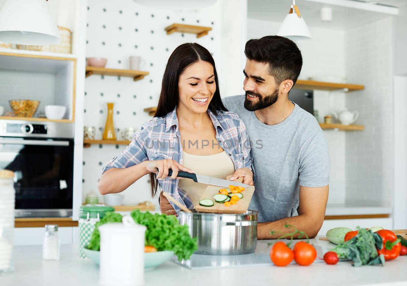 young couple kitchen home cooking love happy together preparation ingredient fun food by Picsfive