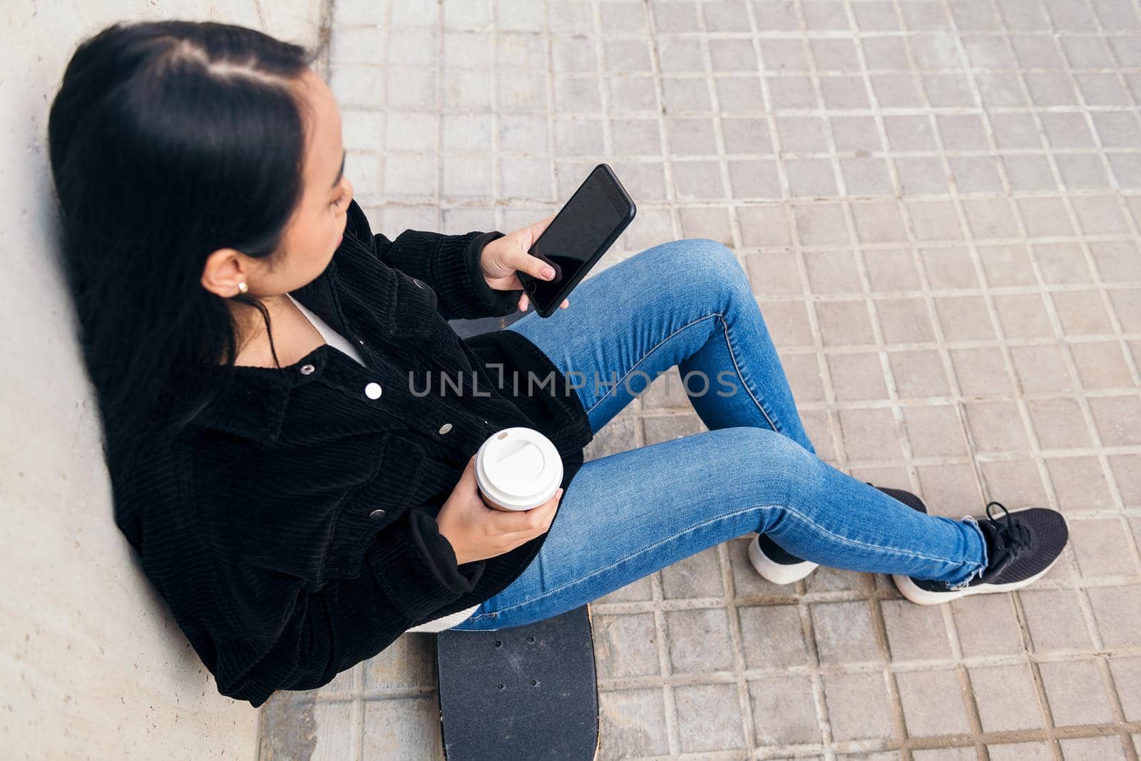 unrecognizable girl typing on a phone outdoors by raulmelldo