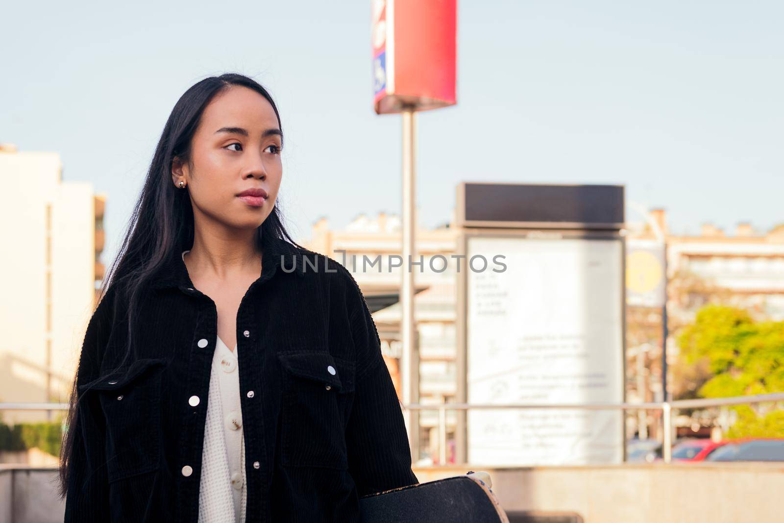 young asian woman waits at subway station exit, concept of urban lifestyle