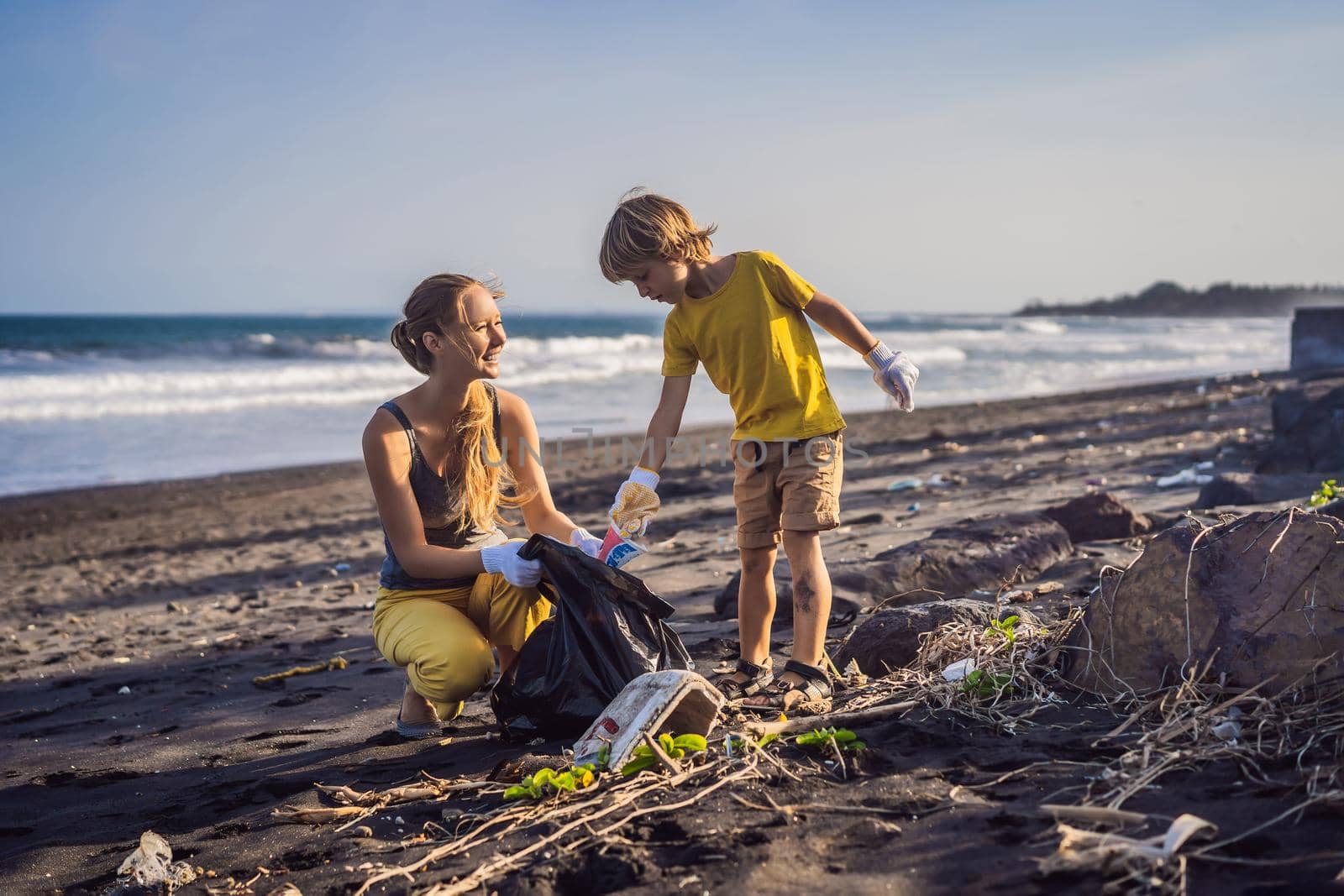 Mother and son are cleaning up the beach. Natural education of children by galitskaya