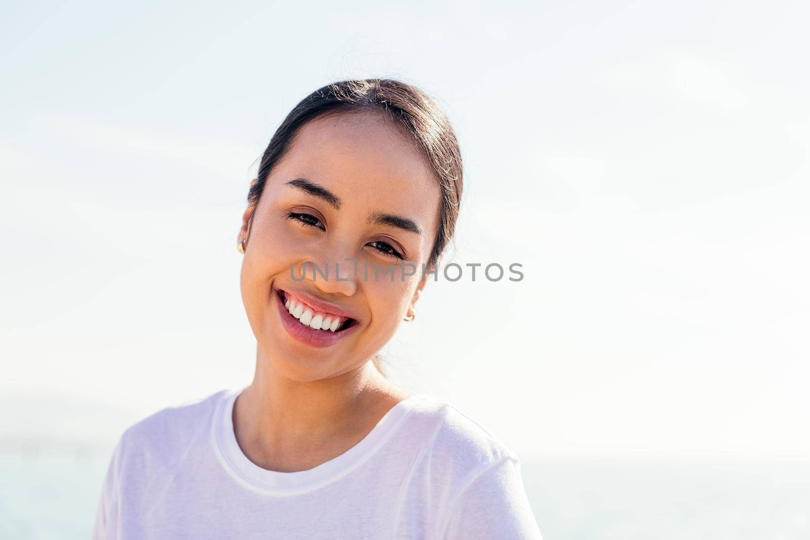happy young asian woman smiles looking at camera, concept of happiness and purity