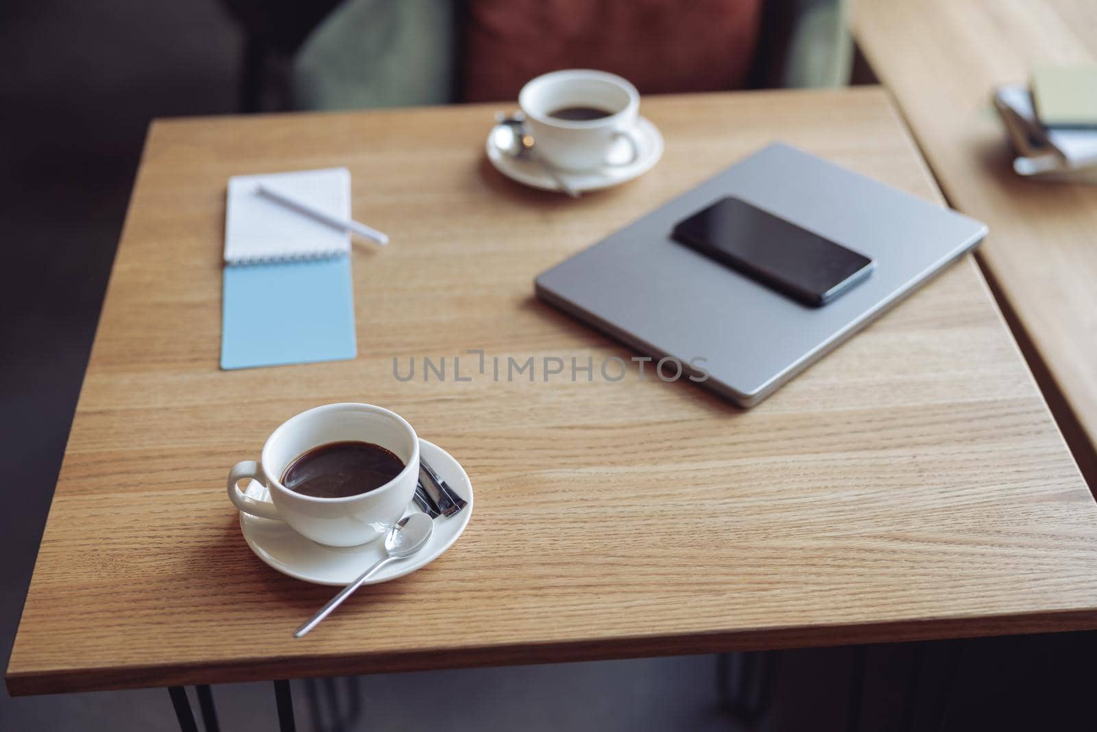 Wooden table with cups of coffee and business objects. Laptop and phone. Ready for meeting concept.