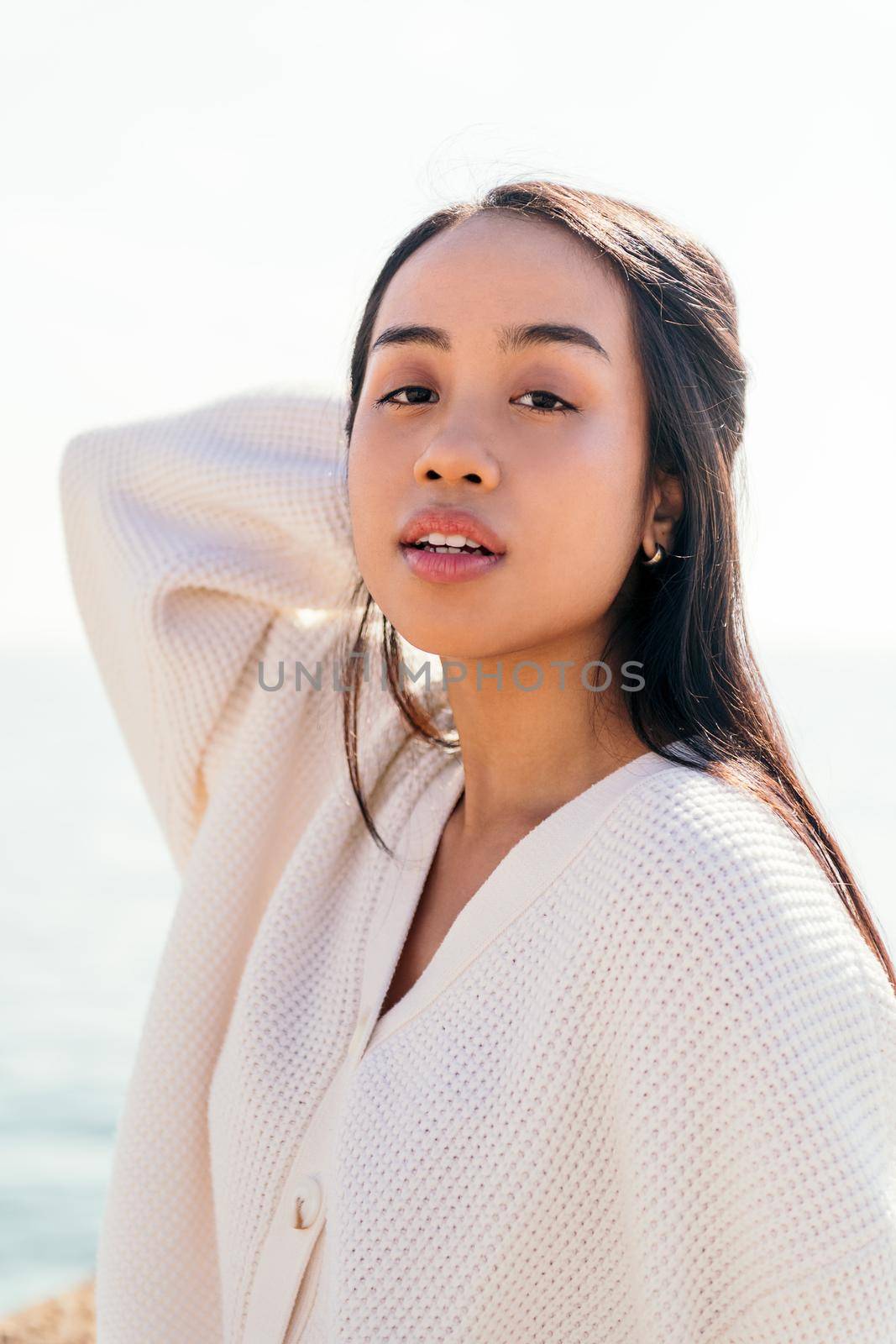 vertical portrait of a young asian woman looking with sensual expression, concept of beauty and purity