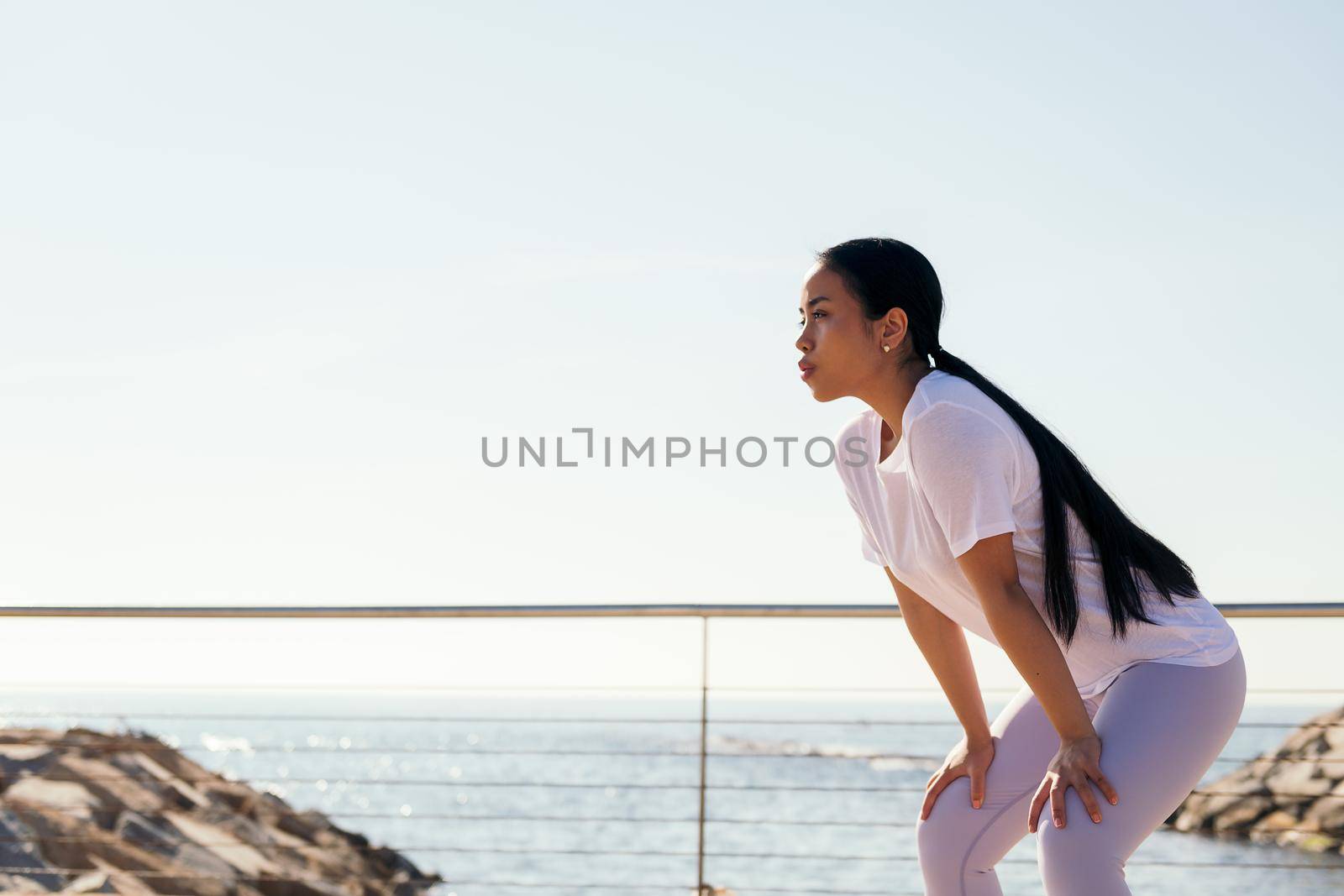 young sports woman tired from effort rests to catch her breath, concept of sport and active lifestyle