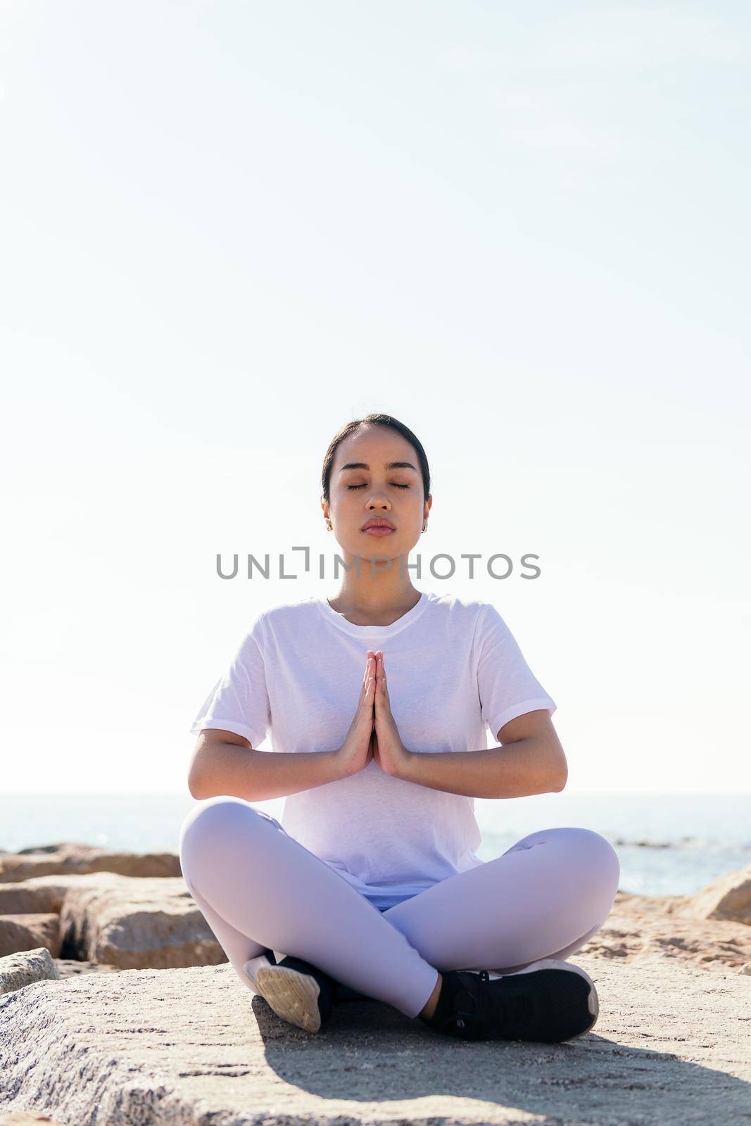 asian woman relaxed meditating sitting outdoors by raulmelldo