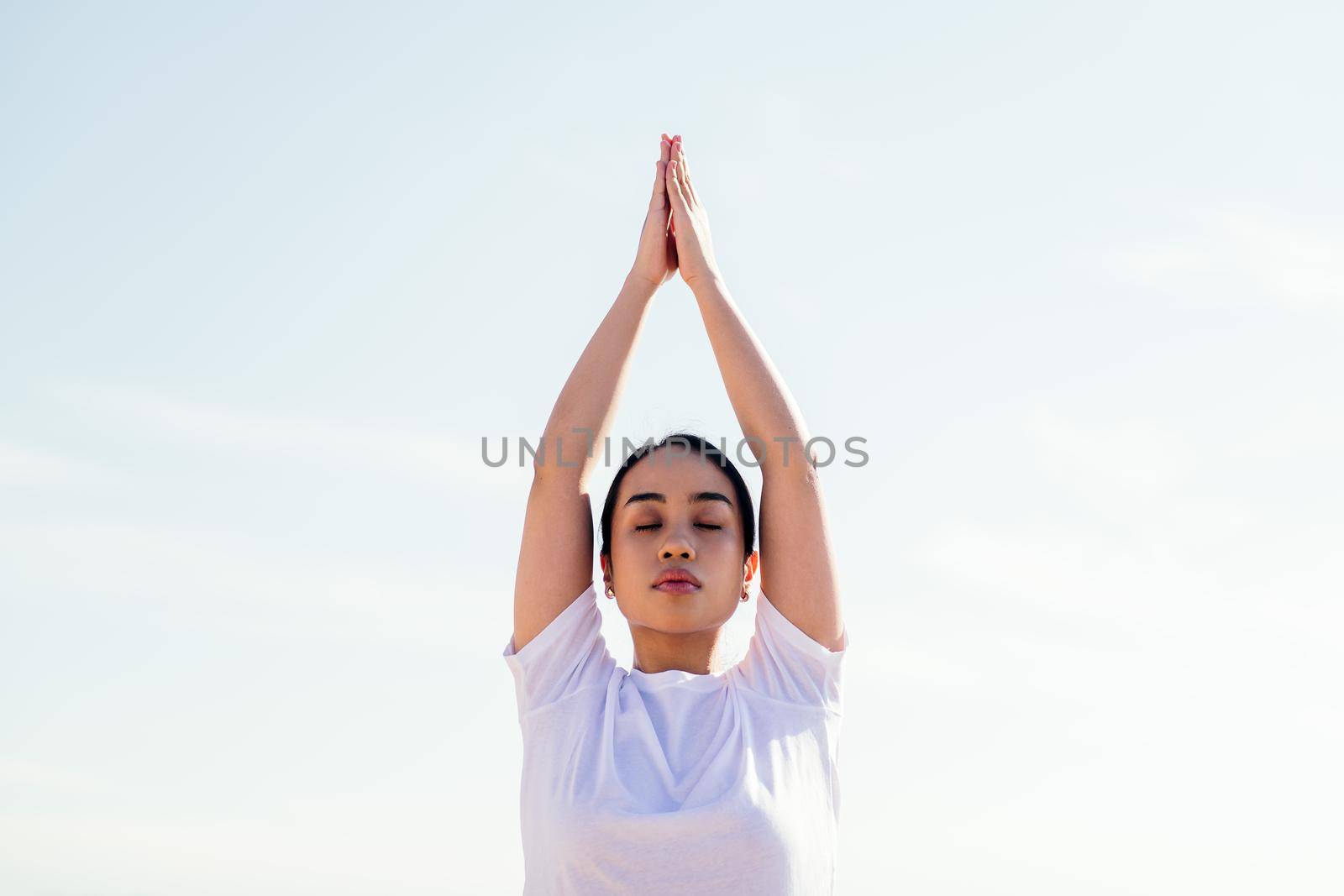 portrait of a young asian woman relaxing while practicing yoga with her eyes closed, concept of spirituality and relax