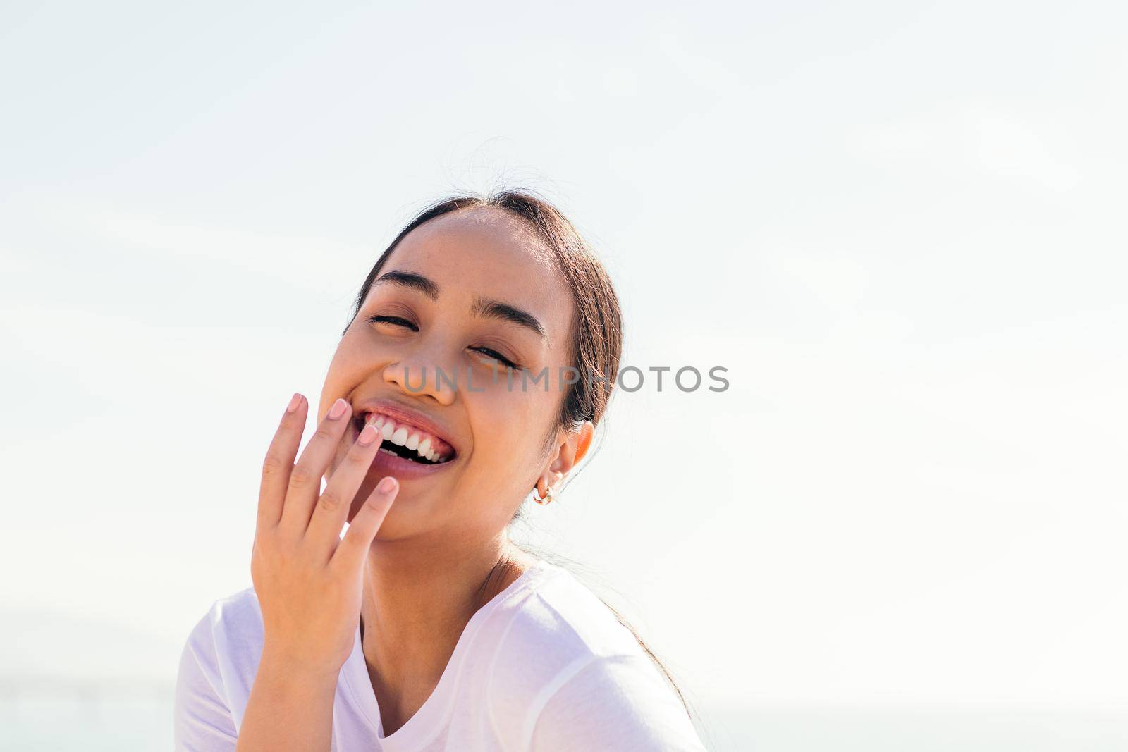 young asian woman laughing with her hand in her mouth, concept of happiness and purity