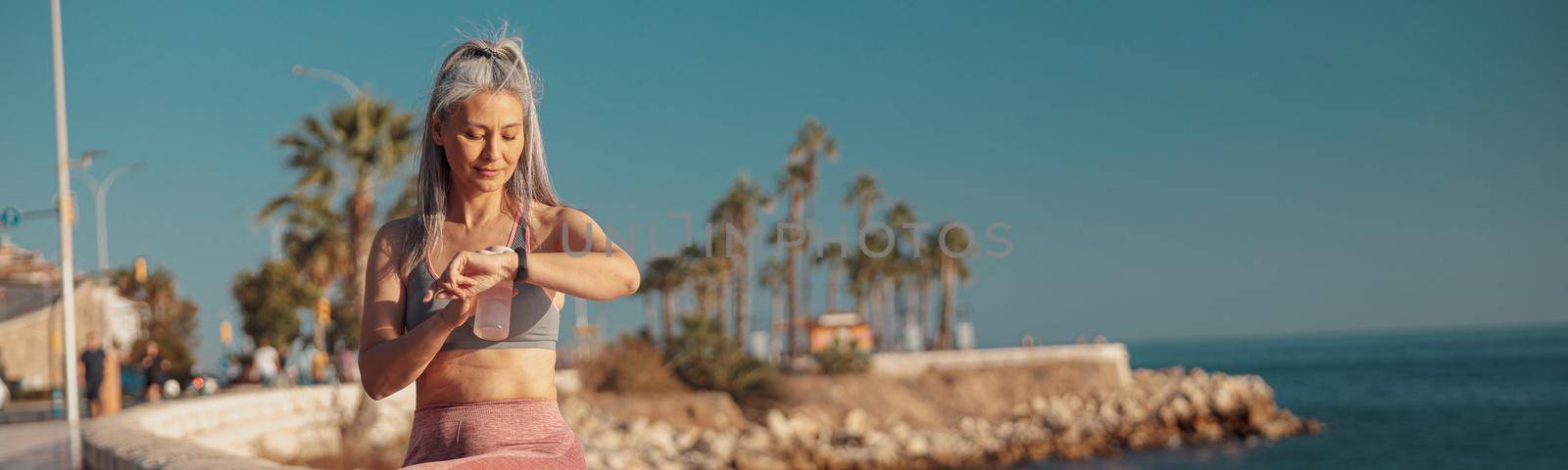 Adult woman resting after training by the waterfront by Yaroslav_astakhov