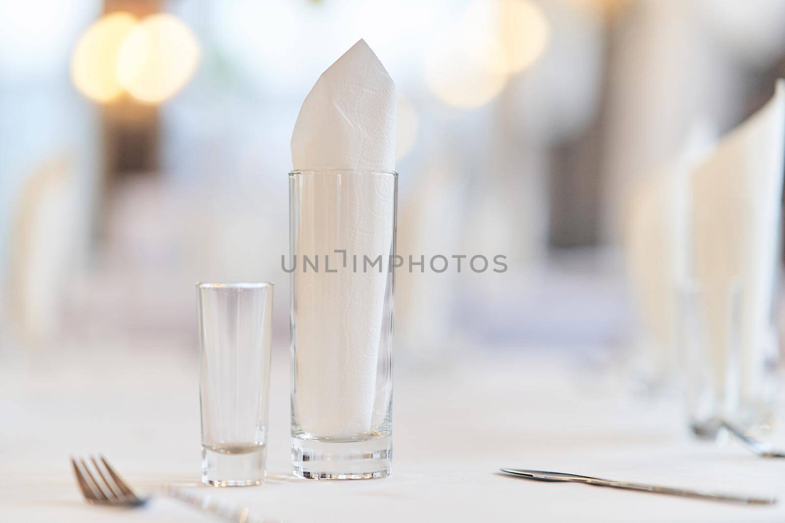 Glass with a glass on the festive table. Festive table setting.