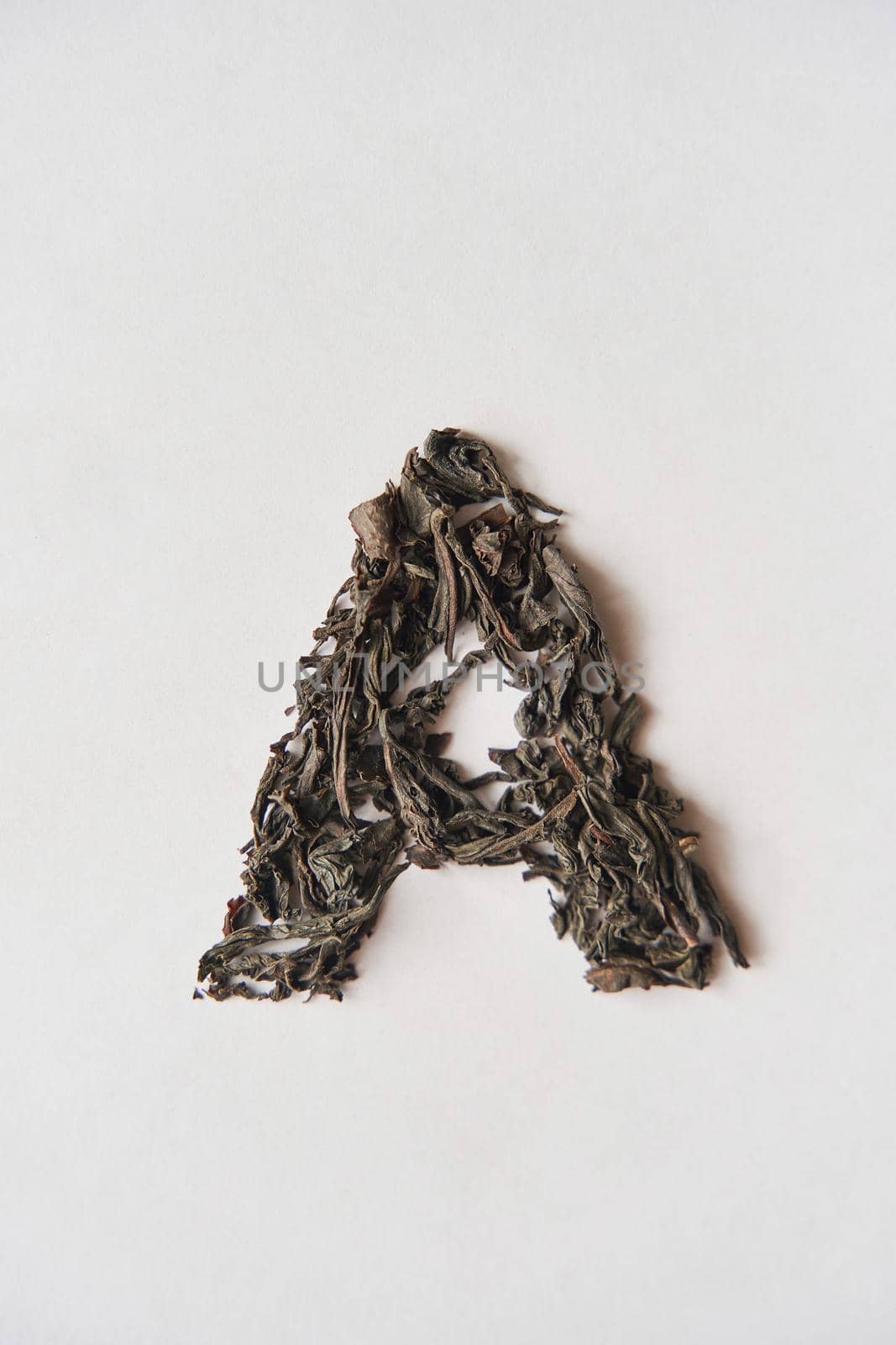 Leaf tea. The inscription A on a white background. Lettering A made by loose tea.