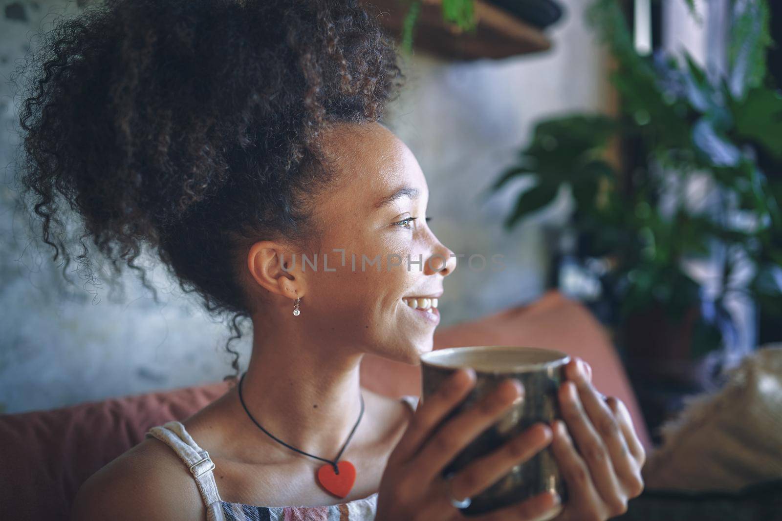 Shot of a beautiful African young woman enjoying a cup of coffee - Stock Photo