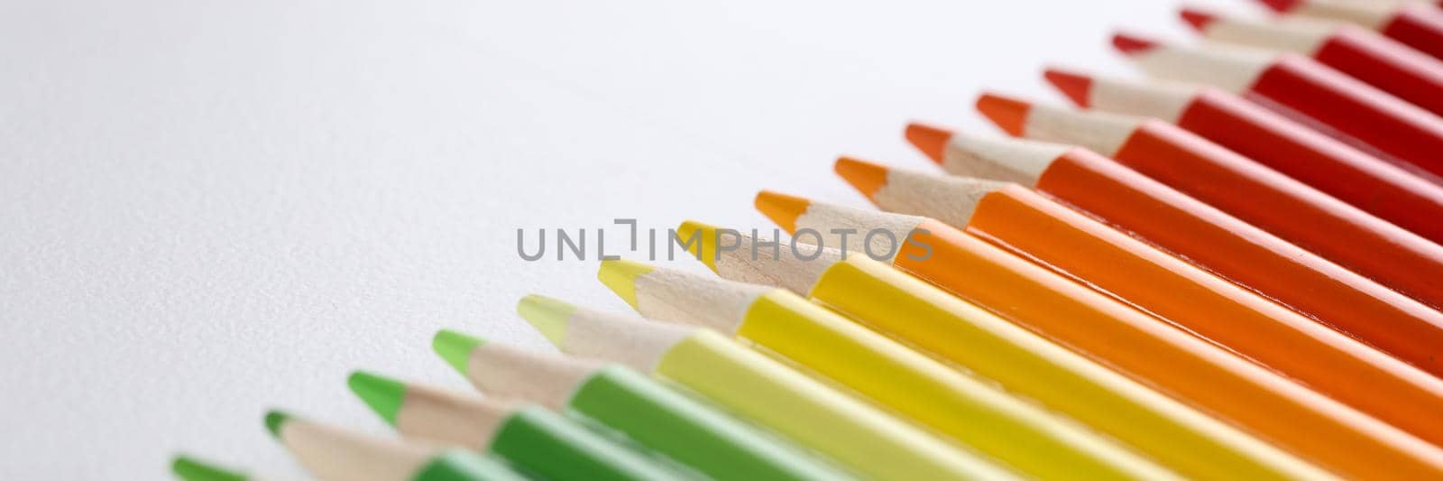 Colored pencils with sharp tips lie in a row, close-up by kuprevich