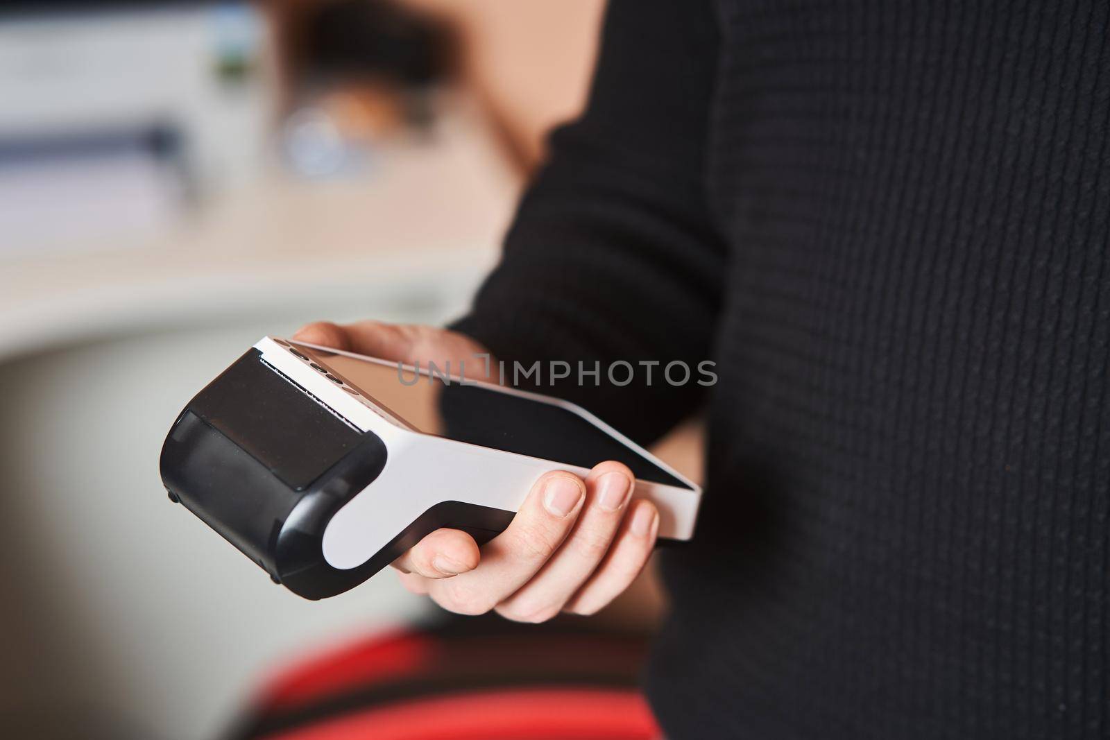 Bank terminal for contactless payment. Acquiring. Young man holds a terminal in his hands.