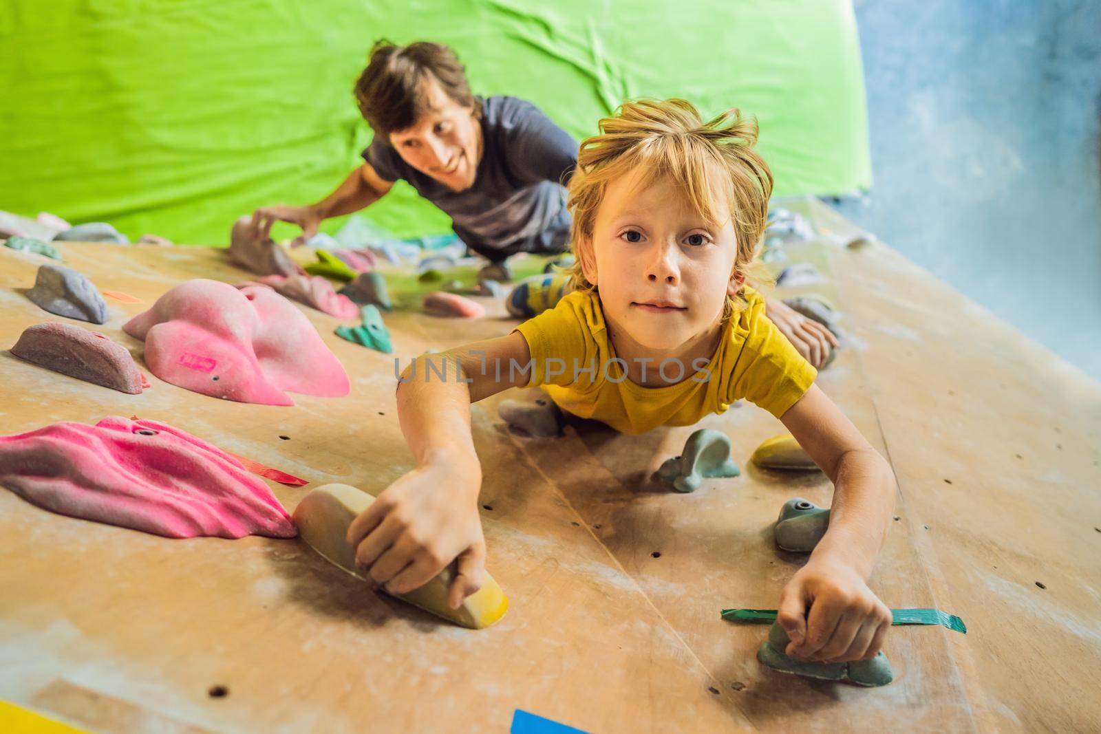 Dad and son at the climbing wall. Family sport, healthy lifestyle, happy family.