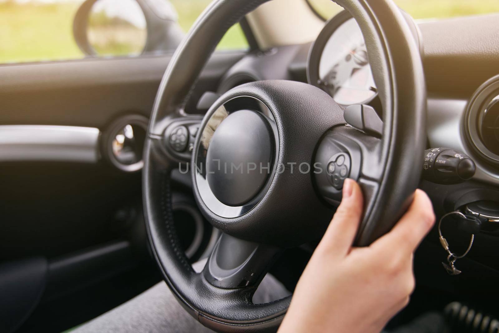Young girl holding a steering wheel. A girl drives a car.