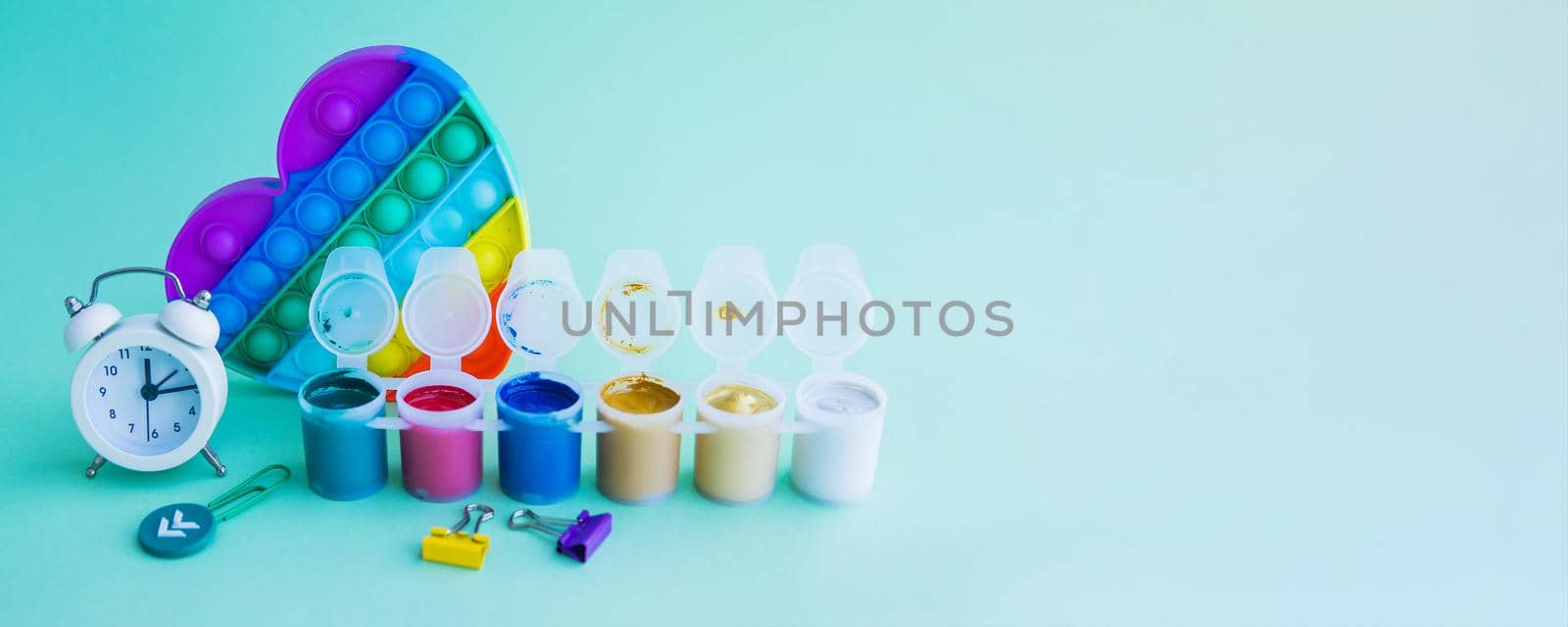 Close-up of stationery and a silicone toy. Blue background. Space for text. Back to school by Annu1tochka