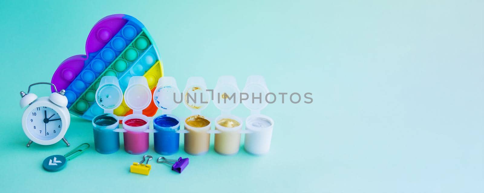 Close-up of stationery and a silicone toy. Blue background. Space for the text. Back to school. Banner.