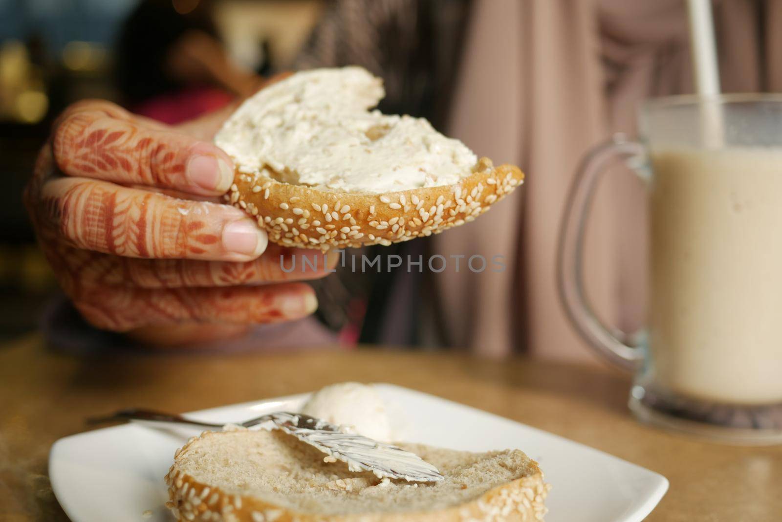 cheese cream spread on fresh bagel bread .
