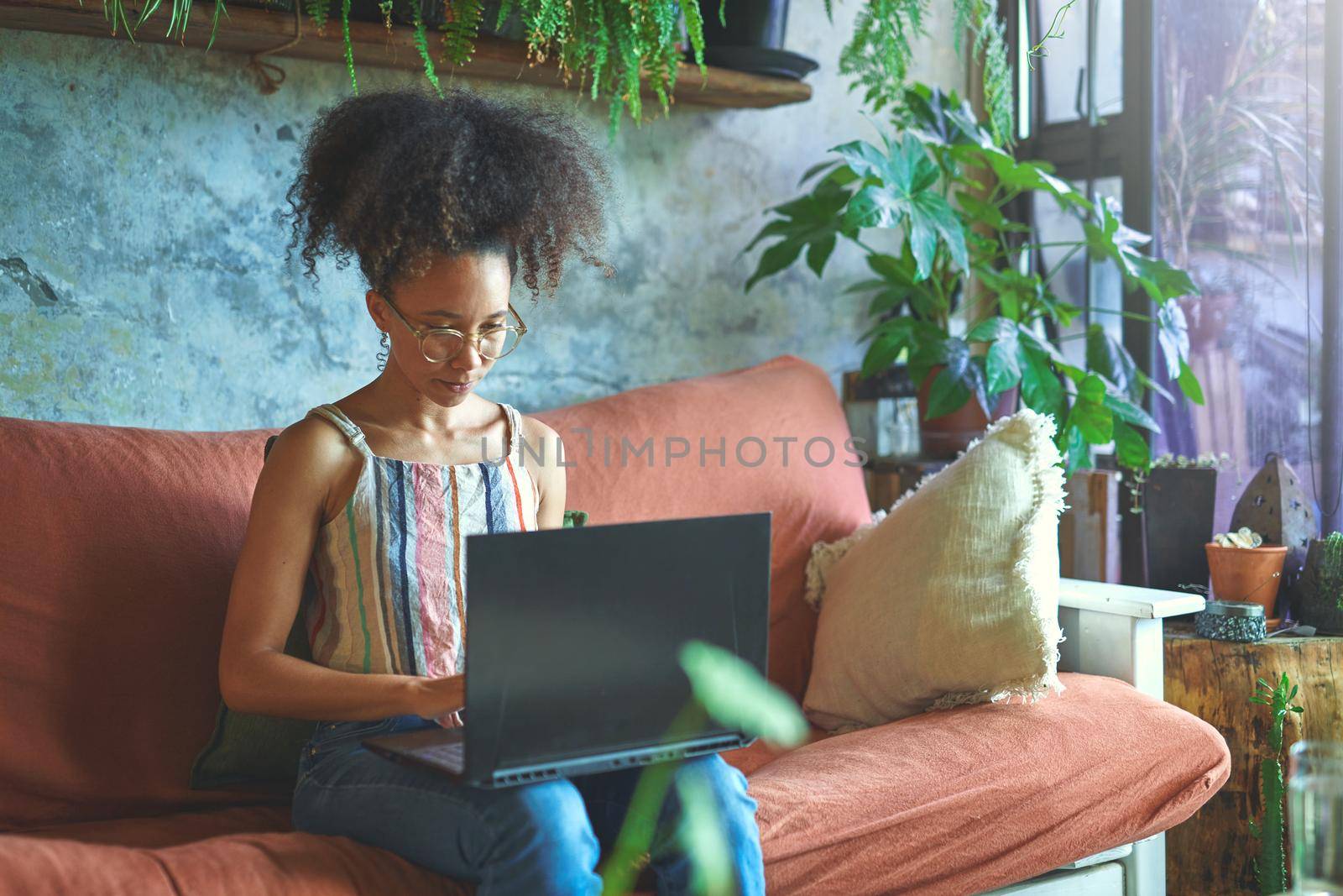 Shot of a beautiful young woman working from her sofa