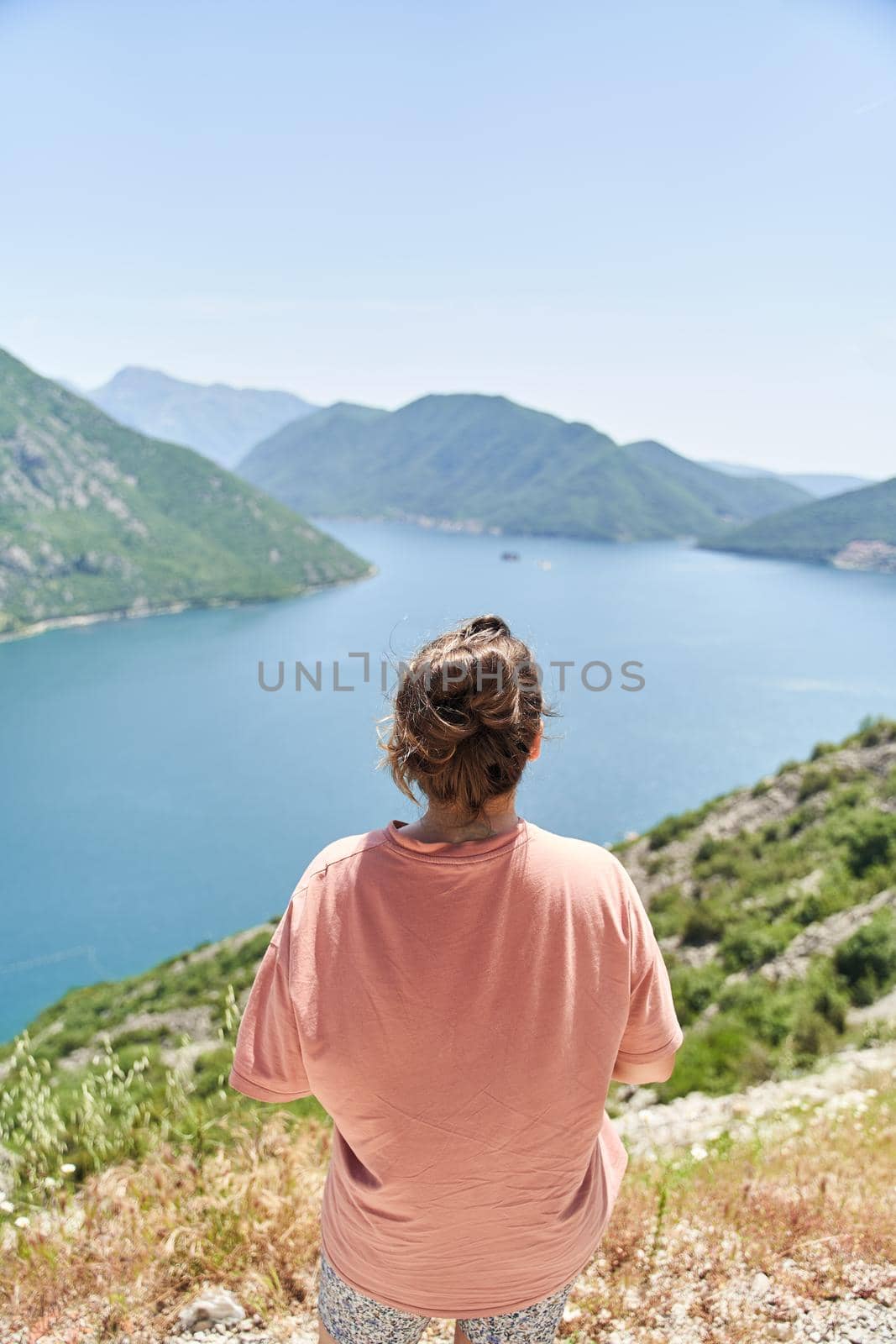 a young girl admires the Bay of Kotor. Photo from the back. High quality photo