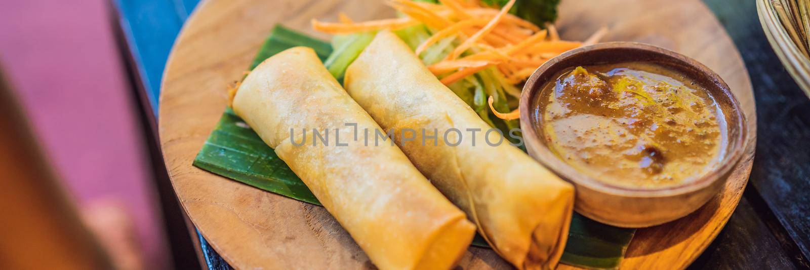 Fried spring rolls served with salad and sauce. Traditional Indonesian and Asian dish BANNER, LONG FORMAT by galitskaya