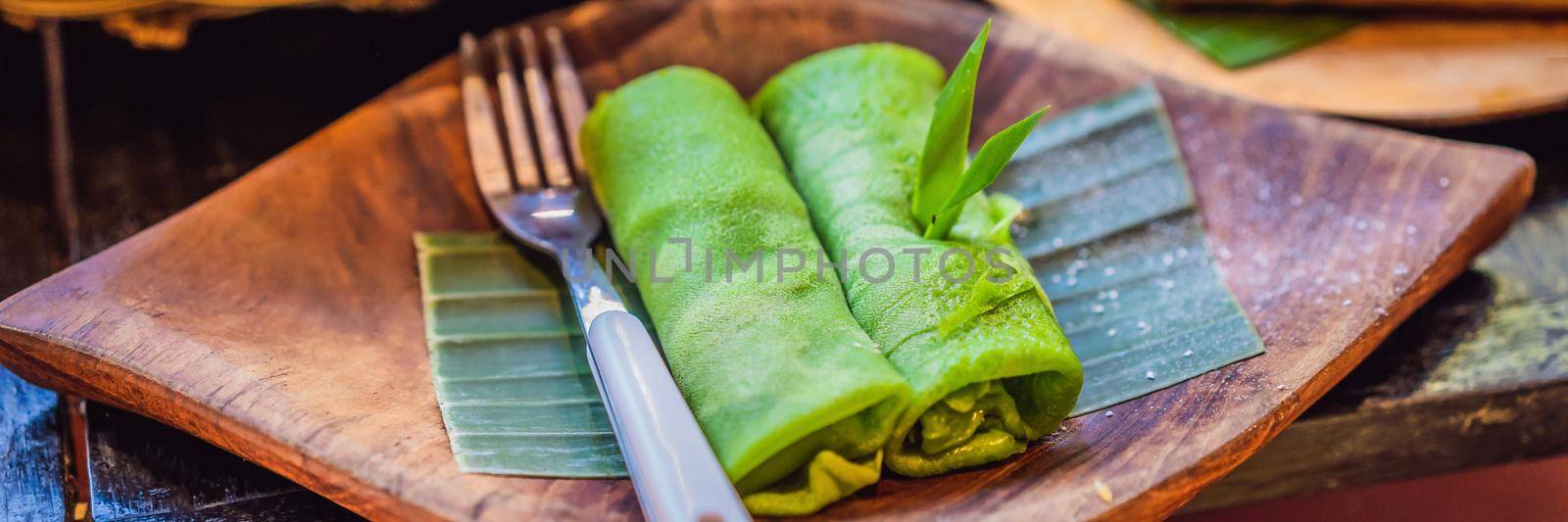 Rolled thin green colored pancake Traditional indonesian food. BANNER, LONG FORMAT