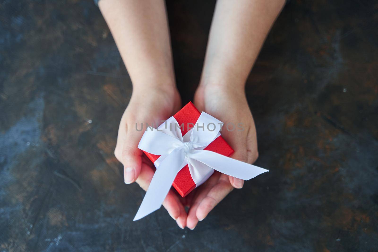 Woman holding small red present box in hands. High-quality photo